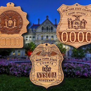 May include: Three wooden ornaments shaped like police badges with the text "New York State Courts" and different titles: "Court Clerk", "Court Officer", and "Sergeant".