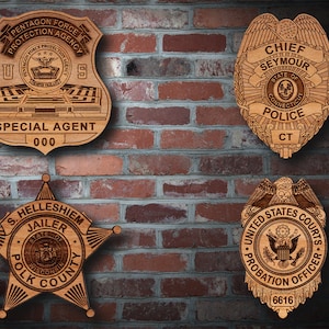 Peut inclure: Quatre badges en bois avec des motifs et des textes différents. Le badge en haut à gauche indique "Pentagon Force Protection Agency" et "Special Agent 000". Le badge en haut à droite indique "Chief Seymour" et "State of Connecticut Police CT". Le badge en bas à gauche indique "S. Hellshiem Jailer State of Wisconsin Polk County". Le badge en bas à droite indique "United States Courts Probation Officer 6616".