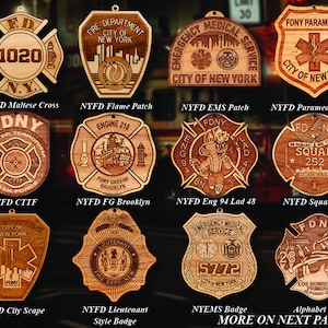 Könnte beinhalten: Eine Sammlung von Holzschmuck mit verschiedenen Designs der Feuerwehr von New York City (FDNY) und des Rettungsdienstes (EMS). Die Ornamente zeigen verschiedene Logos, Embleme und Texte, darunter "FDNY", "Engine 210", "Squad 252", "EMS" und "City of New York".