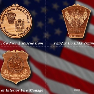 May include: Three wooden engraved plaques with different designs. The first plaque is round and features the text "Fairfax County Fire & Rescue Paramedic Program". The second plaque is shaped like a shield and features the text "Fairfax Co EMS Training" and a winged medical symbol. The third plaque is shaped like a shield and features the text "U.S. Department of the Interior Fire Management".