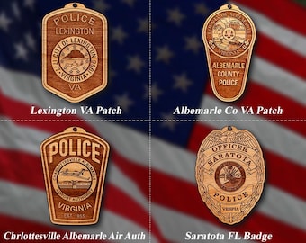 May include: Four wooden police badges with intricate designs. The badges include Lexington VA Patch, Albemarle Co VA Patch, Charlottesville Albemarle Air Auth, and Saratota FL Badge. Each badge features detailed text and emblems.