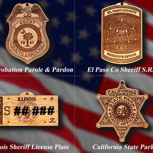May include: Four laser-engraved wooden ornaments featuring law enforcement emblems: SC Probation Parole & Pardon, El Paso Co Sheriff S.R.T., Illinois Sheriff License Plate, and California State Park. Each piece has a small hole for hanging.