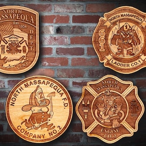 Könnte beinhalten: Vier Holzplaketten mit Feuerwehr-Motiv. Die Plaketten sind alle rund, außer eine, die kreuzförmig ist. Die Plaketten zeigen den Text "North Massapequa" und die Wörter "Fire Dept", "Ladder Co. 1", "Company No. 2" und "Engine Co. 3".