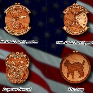 May include: Four wooden ornaments with different designs. The top left ornament is a round, brown wooden disc with a white design of a parachute, a forklift, and a globe. The text "25th AERIAL PORT SQUADRON" and "ANYTIME-ANYWHERE" are inscribed around the design. The top right ornament is a round, brown wooden disc with a white design of an eagle, a lightning bolt, and a globe. The text "94TH AERIAL PORT SQUADRON" and "WE CAN HANDLE IT" are inscribed around the design. The bottom left ornament is a round, brown wooden disc with a white design of an eagle, a star, a feather, and a magnifying glass. The text "INSPECTOR GENERAL" is inscribed around the design. The bottom right ornament is a round, brown wooden disc with a white design of a cat. The text "81st Army" is inscribed below the design.
