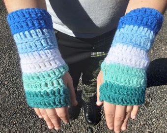 May include: A pair of crocheted fingerless gloves with a blue, light blue, white, light green, and green color pattern.