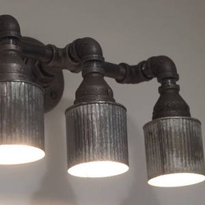 May include: Three industrial-style light fixtures with galvanized metal shades and black pipe accents.