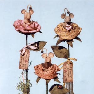 May include: Three handmade fabric mouse figurines in rose-shaped pots. Each mouse holds a heart-shaped object with the text "Love" on it. Each pot has a tag that reads "A flower for thee with from me".