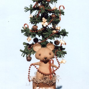 May include: A brown felt mouse with red beads around its neck sits in a rusty tin can decorated with the words "Have yourself a merry little Christmas". The can is topped with a green felt Christmas tree with red and white candy canes, popcorn, and bells.