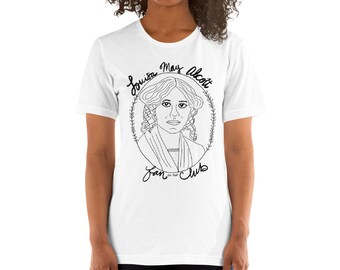 Può includere: Maglietta bianca con un'illustrazione in bianco e nero di Louisa May Alcott. L'illustrazione è in un cerchio con il testo "Louisa May Alcott Fan Club" intorno.