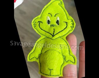 May include: Green felt finger puppet of the Grinch from the film How the Grinch Stole Christmas. The Grinch has a mischievous grin and large, green eyes.