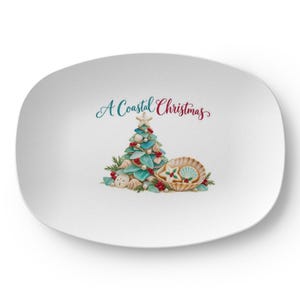 May include: An oval white serving platter featuring a central illustration of a Christmas tree made of sea glass and shells, topped with a starfish. The text A Coastal Christmas is printed above, with a large seashell containing cookies.