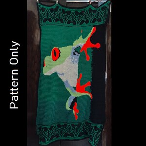 May include: Green crochet blanket with a red and white frog design. The frog is in a jumping pose with its tongue out. The blanket has a black and green border.