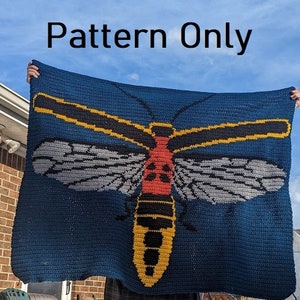 Puede incluir: Una manta de crochet con un insecto grande y colorido con detalles amarillos, negros, rojos y grises. El insecto está centrado en un fondo azul oscuro. El texto "Pattern Only" se muestra en la parte superior de la imagen.