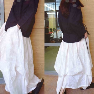 May include: A black long-sleeved shirt with a white skirt. The skirt is gathered and has a layered look.
