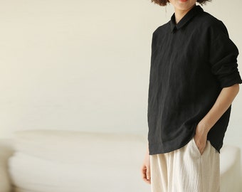 May include: A black linen shirt with a collared neckline and long sleeves. The shirt is loose-fitting and has a relaxed silhouette.