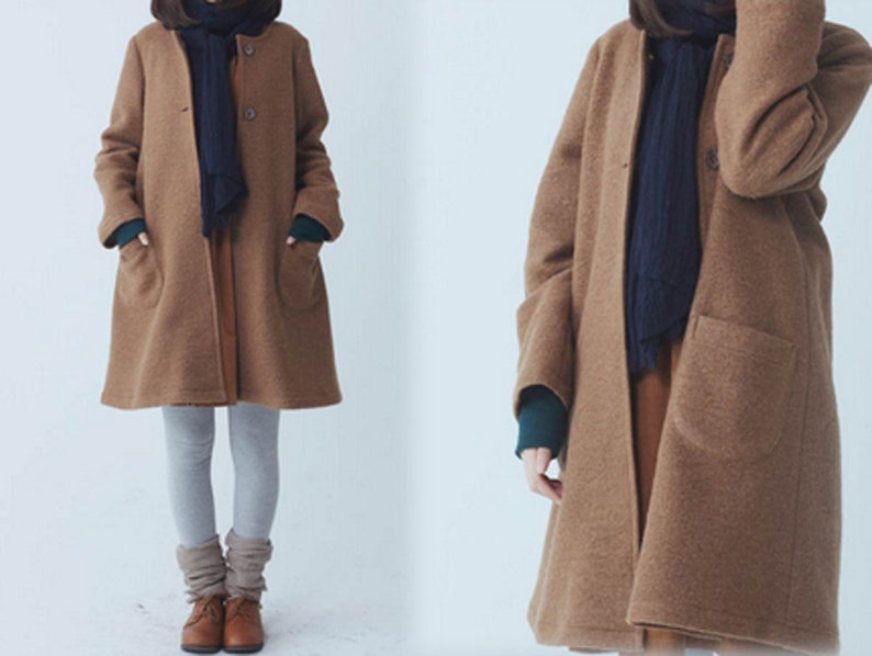 May include: A long-sleeved brown coat with a dark blue scarf and a single button fastening.