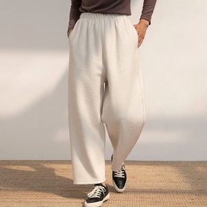 May include: White wide-leg pants with a relaxed fit and a drawstring waistband.