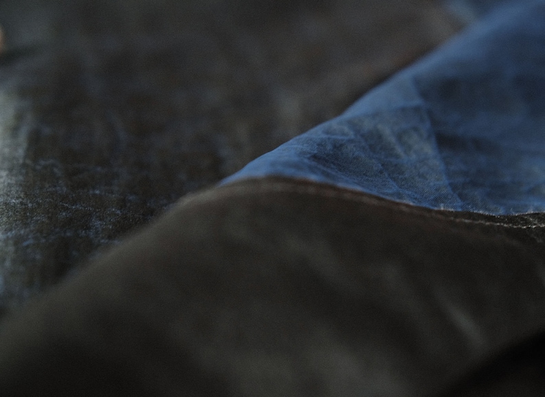 Puede incluir: Primer plano de una tela azul oscura con una tela azul m&aacute;s clara superpuesta. La tela tiene una superficie texturizada, ligeramente rugosa.