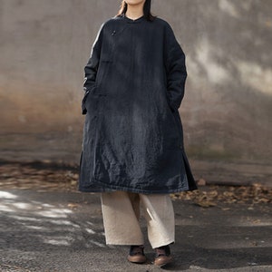 May include: A long, dark blue,  collared,  overcoat with a button closure and side pockets. The coat has a relaxed fit and is made of a soft, textured fabric.