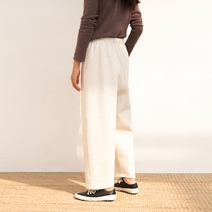 May include: A pair of white wide-leg pants with a drawstring waist.