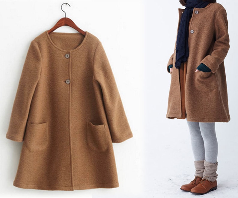 May include: A brown, long-sleeved, button-up coat with a round neckline and two pockets. The coat is made of a soft, textured fabric.