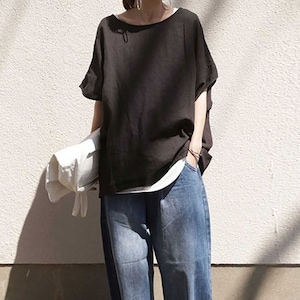 May include: A black, loose-fitting, short-sleeved shirt with a round neckline. The shirt is made of a soft, lightweight fabric and is paired with blue jeans.