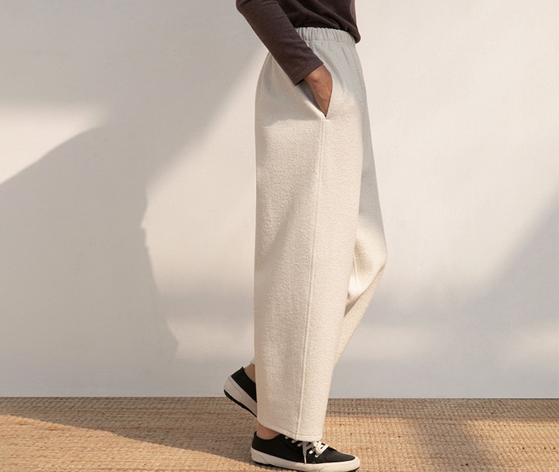 May include: A pair of wide-leg, cream-colored pants with a straight leg and a slightly cropped length. The pants have a simple design and are made of a soft, comfortable fabric.