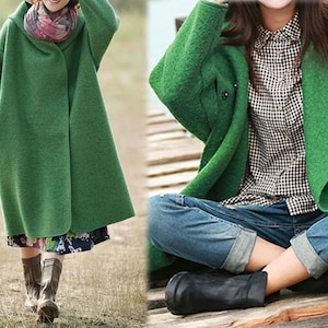 Op de afbeelding: Twee vrouwen dragen groene wollen jassen. De vrouw links draagt een bloemenrok en bruine laarzen. De vrouw rechts draagt een blauwe jeans en zwarte laarzen.