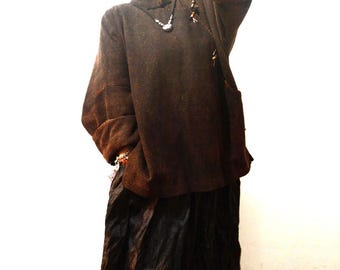 May include: A brown, long-sleeved tunic with a mandarin collar and a silver necklace. The tunic has a loose fit and is made of a textured fabric.