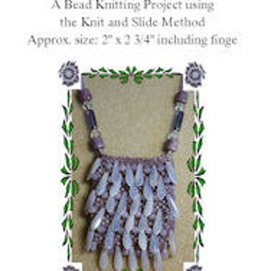 Puede incluir: Un bolso de cuentas con un esquema de color morado y blanco, hecho usando el método de tejido y deslizamiento. El bolso mide aproximadamente 5 cm por 7 cm, incluyendo la flecos. El bolso fue diseñado por Cindy Hulsey y creado en agosto de 2009.