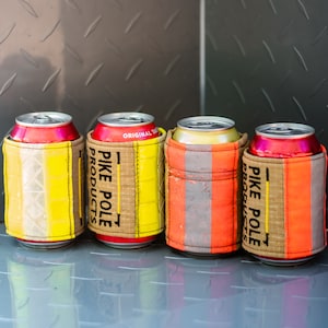 May include: Four red and white can coolers with yellow and orange accents. The coolers are made of fabric and have the text "PIKE POLE PRODUCTS" printed on them.