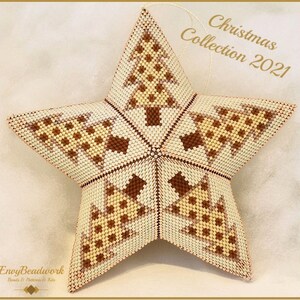 Op de afbeelding: Een stervormige kralenversiering met een witte achtergrond en bruine en beige geometrische patronen. De ster is versierd met kleine kerstboompjes. De tekst "Christmas Collection 2021" is zichtbaar in de rechterbovenhoek van de afbeelding.
