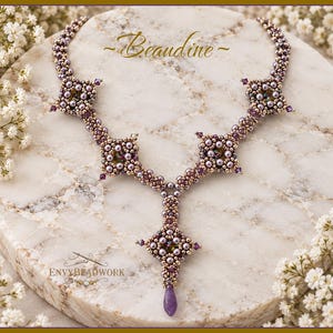 Könnte beinhalten: Eine Perlenkette mit einer Reihe von miteinander verbundenen quadratischen Motiven in metallischen Bronze- und Lavendeltönen, akzentuiert mit kleinen violetten Kristallen und einem zentralen tropfenförmigen Anhänger. Der Text Beaudine und Envybeadwork ist sichtbar.