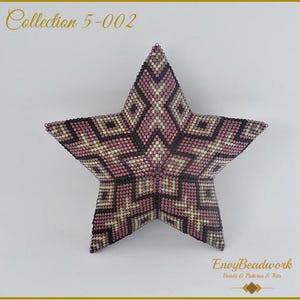 Op de afbeelding: Een stervormige kralenversiering in roze, zwart en gouden tinten. De ster is gemaakt met kleine kralen en heeft een geometrisch patroon. De versiering is gelabeld met "Collection 5-002" en "Envy Beadwork Beads & Patterns & Kits".