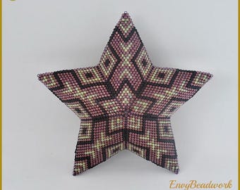 May include: A beaded star ornament in shades of pink, black, and gold. The star is made with small beads and has a geometric pattern. The ornament is labeled "Collection 5-002" and "Envy Beadwork Beads & Patterns & Kits".