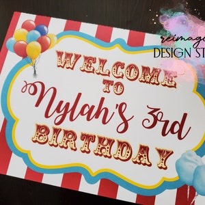 Peut inclure: Panneau d'accueil pour le 3&egrave;me anniversaire de Nylah avec un fond ray&eacute; rouge et blanc, une bordure bleue et jaune et un th&egrave;me de cirque. Le panneau pr&eacute;sente une banni&egrave;re de bienvenue, des ballons et de la barbe &agrave; papa.