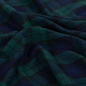 Könnte beinhalten: Ein Stoff mit einem klassischen Schottenkaro-Muster in tiefen Farbtönen von Waldgrün, Marineblau und Schwarz. Das Material ist in weichen, natürlichen Falten und Drapierungen dargestellt, die die Webstruktur und die Linien des Karomusters betonen.