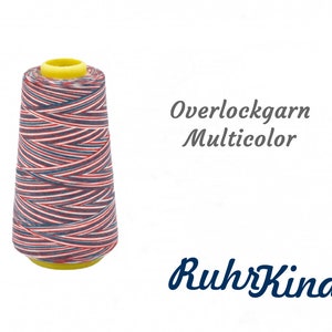 Pode incluir: Uma bobina de fio de overlock multicolorido com listras vermelhas, brancas e azuis. A bobina é etiquetada com "Overlockgarn Multicolor" e "RuhrKind".