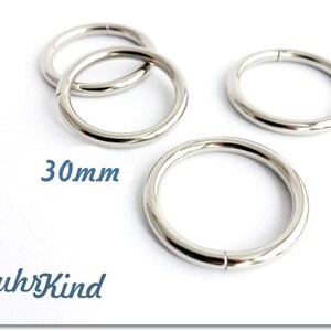 Könnte beinhalten: Mehrere glänzende, silberfarbene Metallringe, jeweils etwa 3 cm im Durchmesser, vor weißem Hintergrund. Der Text "30mm" ist sichtbar, was die Größe angibt. Das Wort "RuhrKind" ist ebenfalls vorhanden.
