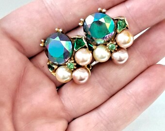 May include: A pair of clip-on earrings with a cluster of faux pearls and green iridescent stones.