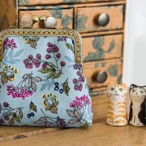 Coin purse made with an Autumn fruits print and a golden leaves lining both by Makower, and a hand stitched bronze colour metal frame