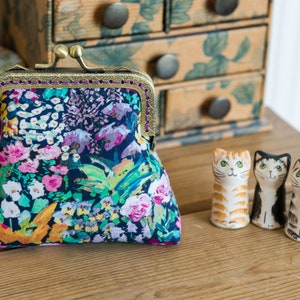 Monedero hecho con Liberty Tana Lawn en el estampado: 'Painter's Meadow', un forro de algodón de color morado oscuro y una estructura de metal de bronce cosida a mano.
