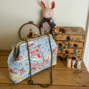 Frame clutch purse with top attachment points for a shoulder strap or wristlet in coastal Summer Liberty cotton print with internal pocket