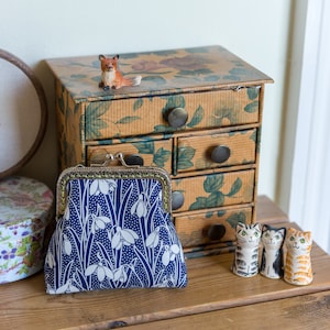 Monedero elaborado con algodón Liberty con estampado Snowdrop, forro verde lima y marco de metal plateado cosido a mano.