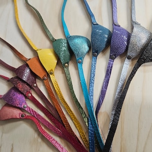 Peut inclure: Un ensemble de dix caches-œil en cuir de différentes couleurs et motifs. Les caches-œil sont en cuir véritable et ont une sangle pour être portés.