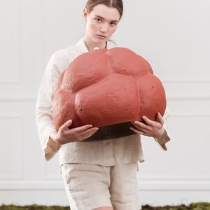sculptural red Pendant Light made from Paper Mache called Sensi hold by a girl
