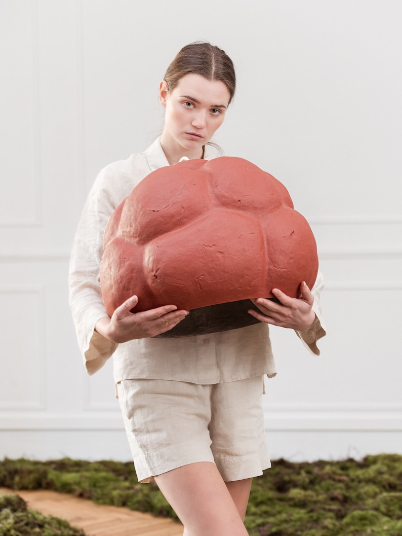 sculptural red Pendant Light made from Paper Mache called Sensi hold by a girl