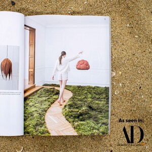 sculptural red Pendant Light made from Paper Mache called Sensi in Architectural digest newspaper