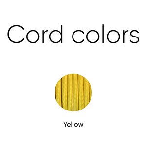 May include: Image displaying three cord color options: cotton white, yellow, and black/white. The text "Cord colors" is at the top. Each color is presented in a circular format, showcasing the texture and hue of the cords.