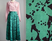 Midi skirt pleated in wool, green with abstract black print, pockets, medium flare, 1950s style, size S, vintage/spring/fall, made in GB